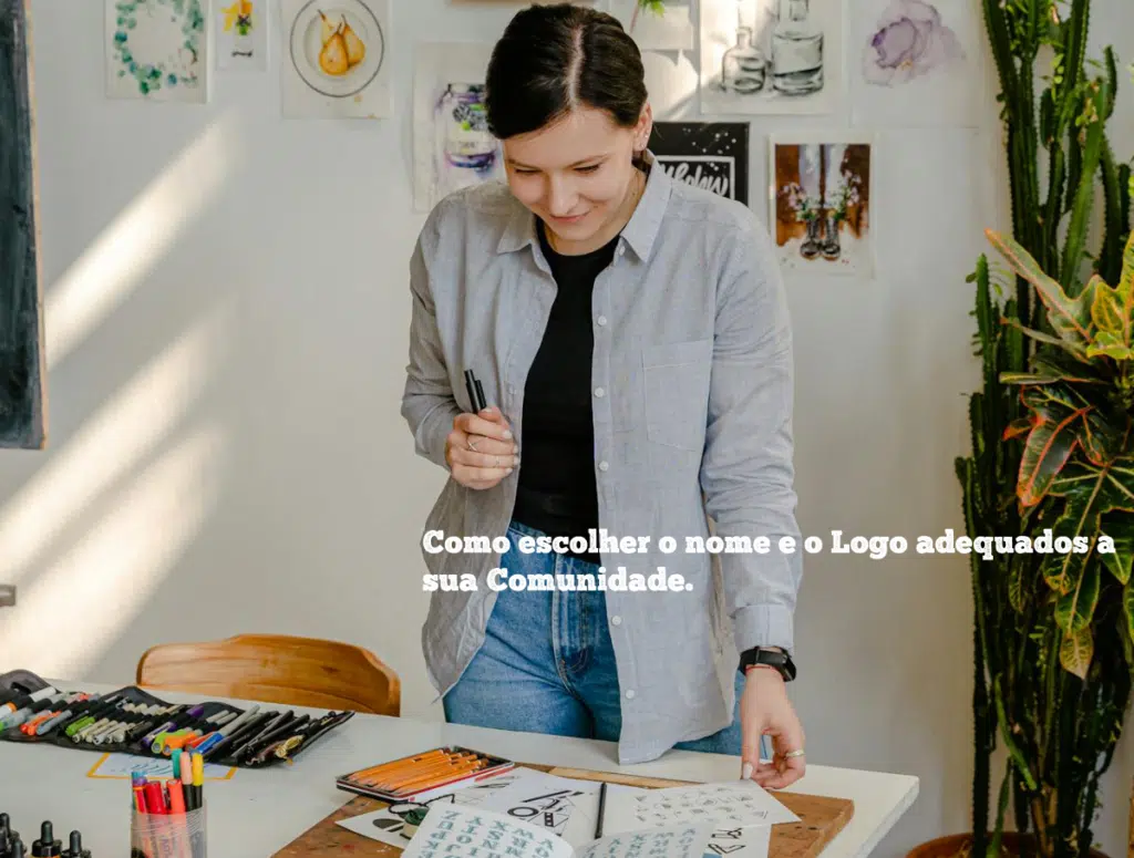 Mujer en una pieza iluminada rodeada de ilustraciones en la pared. Está escogiendo algo en unos libros.