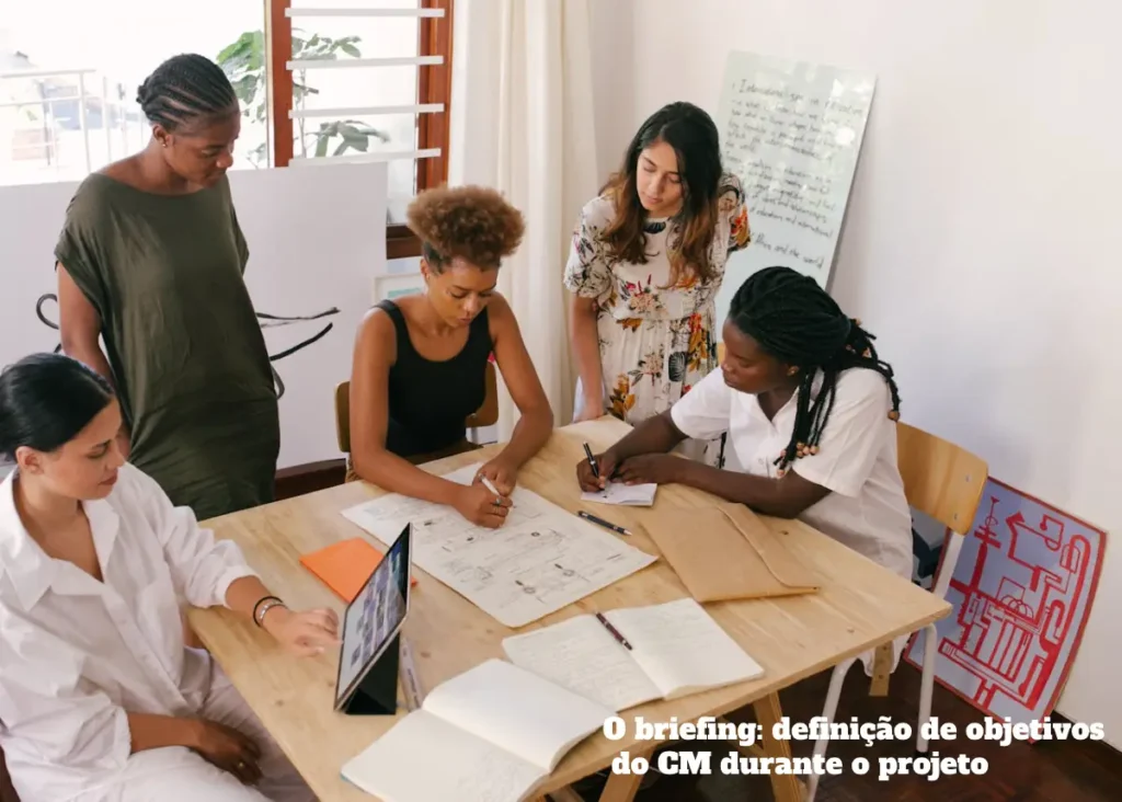 Personas alrededor de una mesa conversando sobre un proyecto.