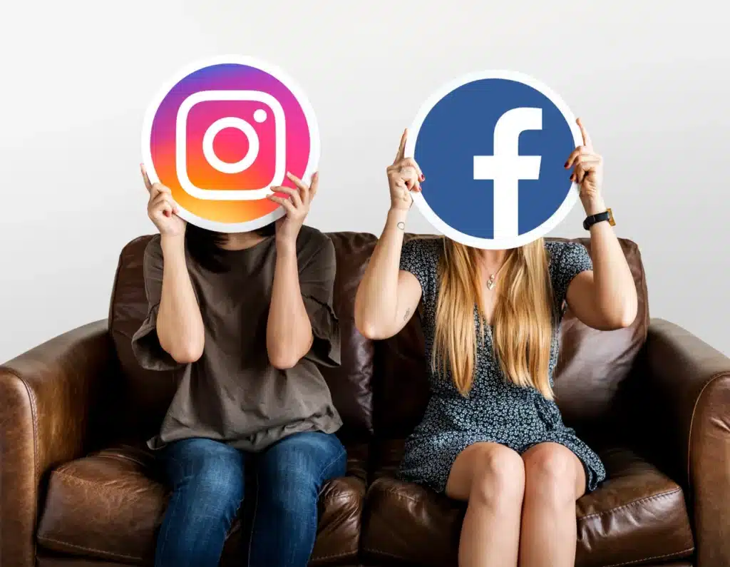 Dos personas sostienen en sus rostros las imagenes de Instagram y Facebook.